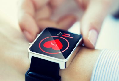 Technology,,Health,Care,And,People,Concept,-,Close,Up,Of technology, health care and people concept - close up of woman hands checking pulse by smartwatch with heart icon on screen